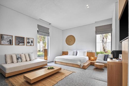 a bedroom with a bed and a couch and a tv at Voyage Torba Hotel in Torba