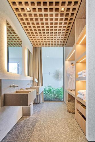 a bathroom with a sink and a large window at Voyage Torba Hotel in Torba