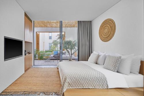 a bedroom with a white bed and a television at Voyage Torba Hotel in Torba