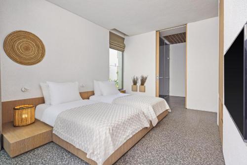two beds in a room with white walls at Voyage Torba Hotel in Torba