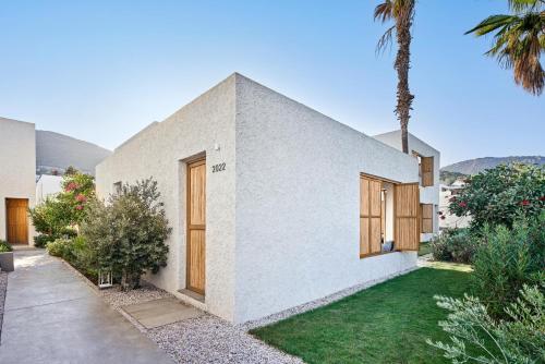 a white house with wooden doors and a yard at Voyage Torba Hotel in Torba