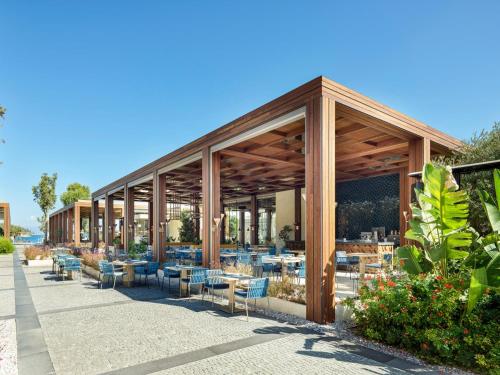 a restaurant with tables and chairs in a building at Voyage Torba Hotel in Torba