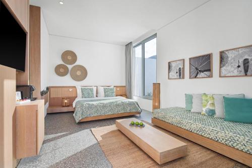 a living room with two beds and a tv at Voyage Torba Hotel in Torba