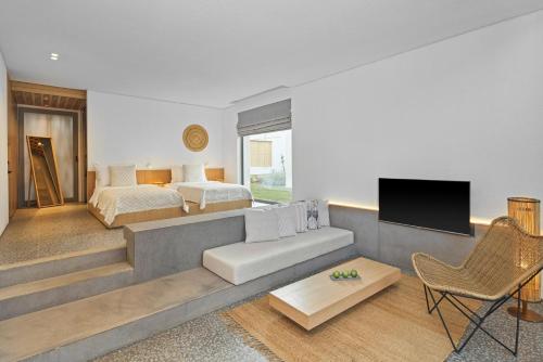 a living room with a bed and a couch and a tv at Voyage Torba Hotel in Torba