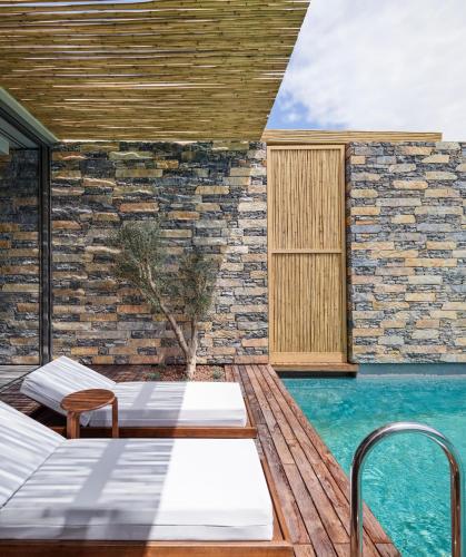 a patio with two beds and a swimming pool at Voyage Torba Hotel in Torba
