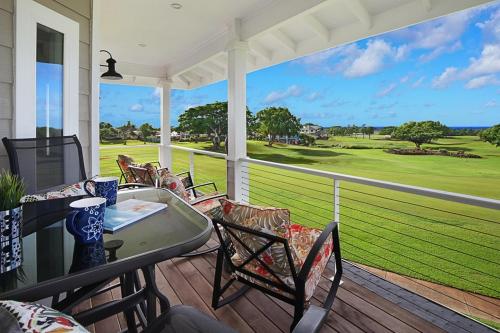 a porch with a table and chairs and a view of a golf course at Haupu Hale at Poipu in Koloa