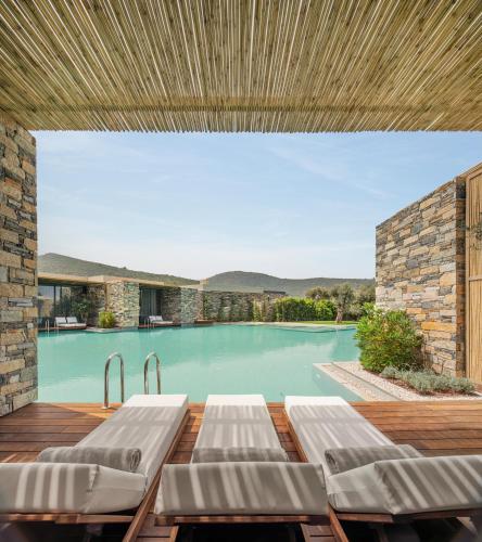 a swimming pool with chaise lounges on a wooden deck at Voyage Torba Hotel in Torba