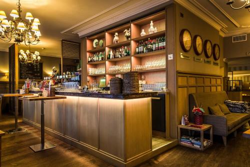 a bar with a counter in a room at Hotel De Limbourg in Sittard