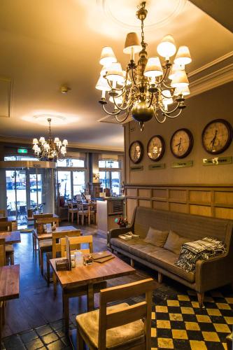 a restaurant with tables and clocks on the wall at Hotel De Limbourg in Sittard