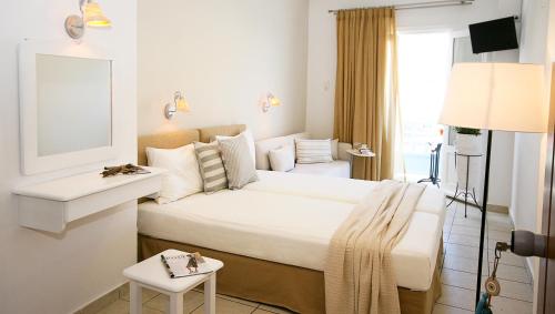 ein Hotelzimmer mit einem großen Bett und einem Fenster in der Unterkunft Paradissos Hotel in Pera Gyalos