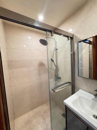 a bathroom with a glass shower and a sink at the 5th floor in Baguio