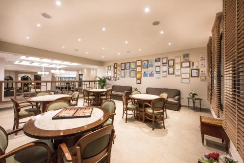a restaurant with tables and chairs and pictures on the wall at Nana Golden Beach All Inclusive Resort & Spa in Hersonissos