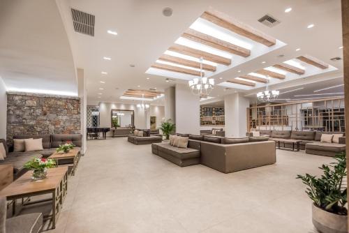 a library with couches and tables and bookshelves at Nana Golden Beach All Inclusive Resort & Spa in Hersonissos