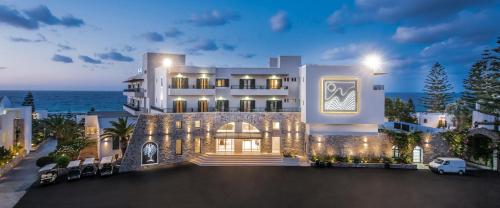 a large white house with the ocean in the background at Nana Golden Beach All Inclusive Resort & Spa in Hersonissos