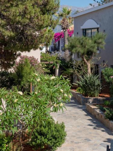 a garden with trees and bushes in front of a house at Nana Golden Beach All Inclusive Resort & Spa in Hersonissos