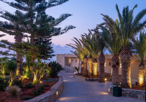 a courtyard with palm trees and lights at night at Nana Golden Beach All Inclusive Resort & Spa in Hersonissos