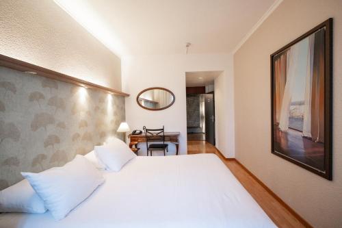 Postel nebo postele na pokoji v ubytování Hotel Les Arcades
