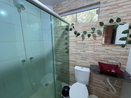 a bathroom with a glass shower and a toilet at Casa com piscina em São Jorge Go in Alto Paraíso de Goiás
