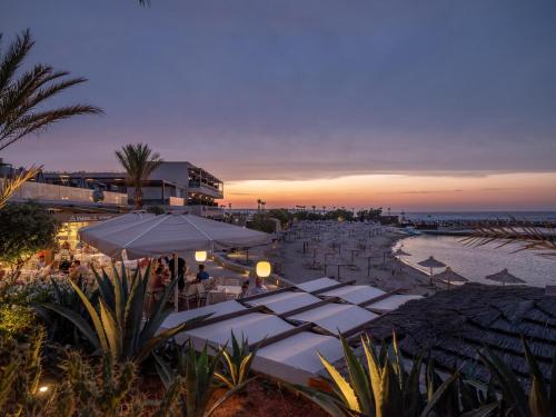 a group of tables with umbrellas on a beach at Nana Golden Beach All Inclusive Resort & Spa in Hersonissos