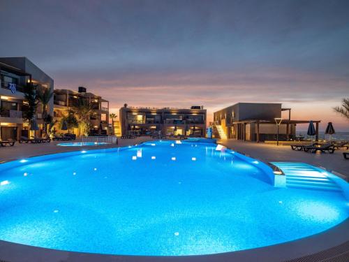 a large blue swimming pool with buildings in the background at Nana Golden Beach All Inclusive Resort & Spa in Hersonissos