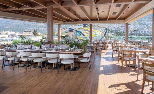 a restaurant with tables and chairs and a view at Nana Golden Beach All Inclusive Resort & Spa in Hersonissos