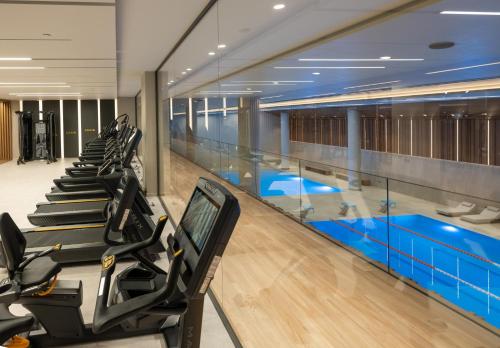 a gym with a swimming pool and tread machines at Nana Golden Beach All Inclusive Resort & Spa in Hersonissos