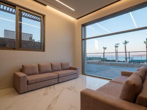 a living room with two couches and a large window at Nana Golden Beach All Inclusive Resort & Spa in Hersonissos