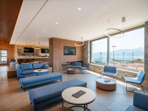 a living room with blue furniture and a large window at Nana Golden Beach All Inclusive Resort & Spa in Hersonissos