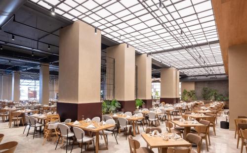 a large dining hall with tables and chairs at Nana Golden Beach All Inclusive Resort & Spa in Hersonissos