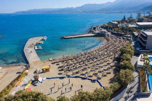 a beach with a bunch of umbrellas and the ocean at Nana Golden Beach All Inclusive Resort & Spa in Hersonissos