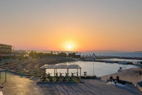 a sunset over a body of water with a pier at Nana Golden Beach All Inclusive Resort & Spa in Hersonissos