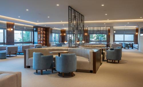 a hotel lobby with chairs and tables and windows at Nana Golden Beach All Inclusive Resort & Spa in Hersonissos