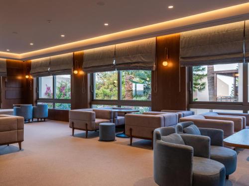 a waiting room with chairs and tables and windows at Nana Golden Beach All Inclusive Resort & Spa in Hersonissos