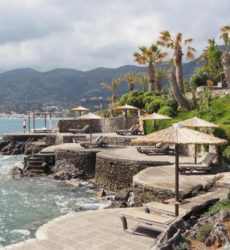 a beach with chairs and umbrellas and the water at Nana Golden Beach All Inclusive Resort & Spa in Hersonissos
