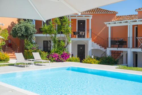 a swimming pool in front of a house at Felix Hotels - Galanias Hotel & Retreat in Bari Sardo
