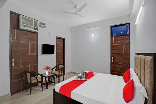 Un dormitorio con una cama, una mesa y una silla. en Hotel O Raj Residency, en Nueva Delhi