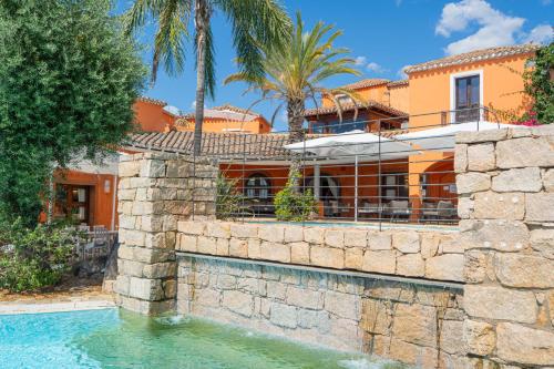 a house with a swimming pool in front of a house at Felix Hotels - Galanias Hotel & Retreat in Bari Sardo