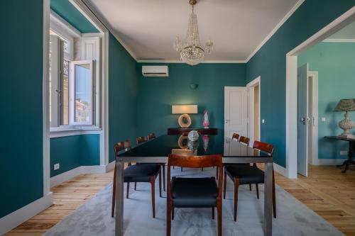 a dining room with green walls and a table and chairs at Casas de São Bento in Lisbon