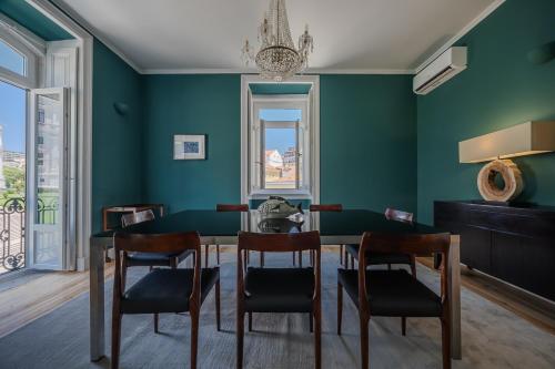 a dining room with green walls and a table and chairs at Casas de São Bento in Lisbon