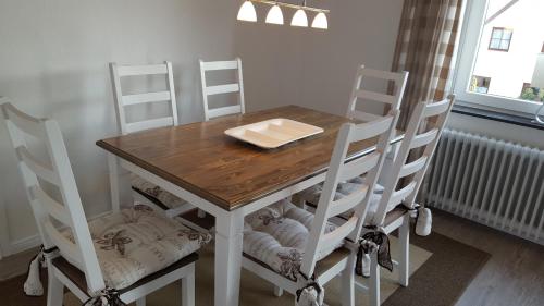 a dining room table with four chairs and a wooden table at FeWo Machedanz zentrumsnah & ruhig Timmendorfer Strand in Timmendorfer Strand