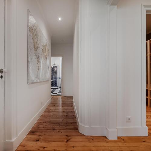 an empty hallway with white walls and wood floors at Casas de São Bento in Lisbon