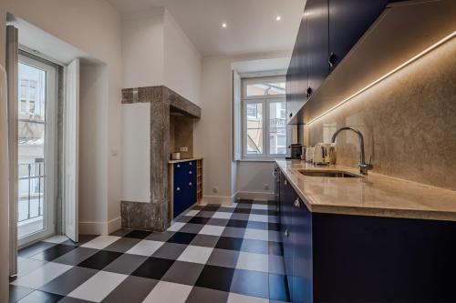 a kitchen with a black and white checkered floor at Casas de São Bento in Lisbon