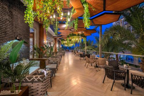 a restaurant with tables and chairs and plants at Sidera Kirman Premium - Ultra All Inclusive in Okurcalar
