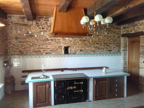 a kitchen with an island in a brick wall at Casa Grande de Anllo in Sistallo