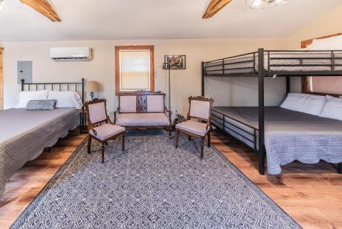 a bedroom with two bunk beds and two chairs at The Outpost in Grand Rivers