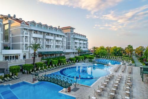 una imagen de un complejo con 2 piscinas y sillas en Trendy Aspendos Beach Hotel, en Side