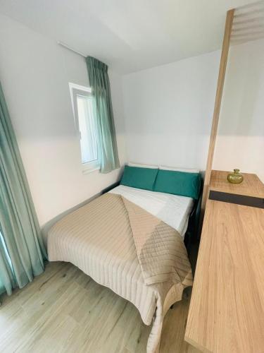 a bed in a small room with green curtains at La Titina Sangi in Bari