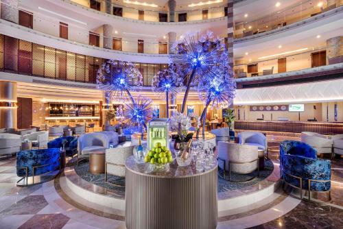 a lobby of a hotel with blue chairs and a bar at Leodikya Kirman Premium - Ultra All Inclusive in Okurcalar