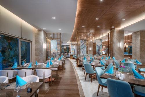 a restaurant with blue chairs and tables in a room at Leodikya Kirman Premium - Ultra All Inclusive in Okurcalar