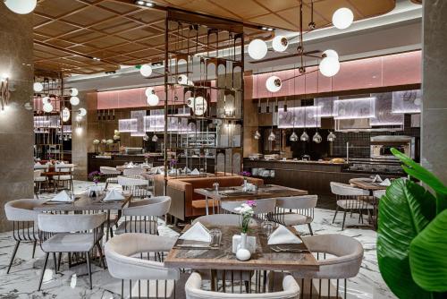a restaurant with tables and chairs and a kitchen at Leodikya Kirman Premium - Ultra All Inclusive in Okurcalar